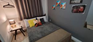 a small bed in a small room with a table at Suite Flex ao lado da praca central in Domingos Martins