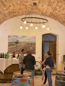 a group of people standing at a bar in a room at Dimora dell'Arte-CantinArte in Navelli