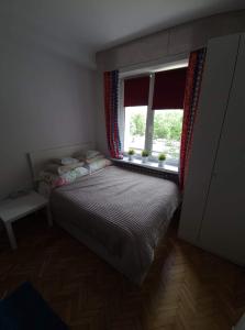 Habitación pequeña con cama y ventana en Apartament Waszyngtona, en Varsovia