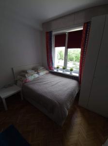 a small bedroom with a bed and a window at Apartament Waszyngtona in Warsaw