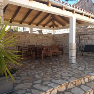 a patio with a table and chairs under a pavilion at Apartments Tomina in Donje Selo na Šolti