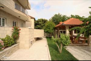 um quintal de uma casa com um gazebo em Apartmani Aleksic em Trebinje