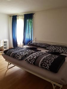 two beds in a bedroom with blue curtains at 2 Rooms cosy Apartment near Liechtenstein in Haag