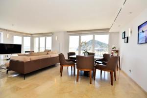 a living room with a couch and a table and chairs at Atico Suite Ola Blanca in Cala de Finestrat