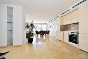 a large kitchen with a table and a dining room at Atico Suite Ola Blanca in Cala de Finestrat
