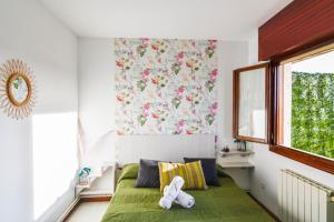 Un dormitorio con una cama verde con un animal de peluche. en Apartamento con vistas al mar-Ola del atardecer en Mogro