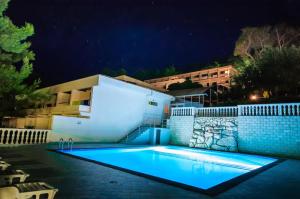 ein Schwimmbad vor einem Haus in der Nacht in der Unterkunft Hotel Mirta in Božava