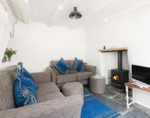 een woonkamer met een bank en een open haard bij Bre Cottage in Port Isaac