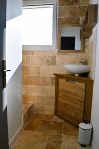 ein Badezimmer mit Waschbecken und Spiegel in der Unterkunft La maison penchée, avec jardin à 50m de la plage in Asnelles