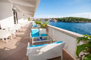 a balcony with chairs and a view of the water at Hotel Mirta in Božava