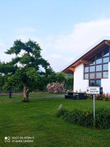 ein Schild vor einem Gebäude mit einem Baum in der Unterkunft Agritur Deromedi in Cles