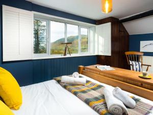 a bedroom with a bed and a table and windows at Flaska House in Penrith