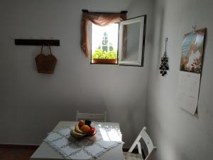 - une table avec un bol de fruits et une fenêtre dans l'établissement Estudio Al Bab, à Chiclana de la Frontera