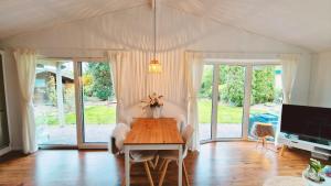 a dining room with a table and a tv at Vakantiehuisje Vechtdal in Stegeren