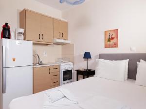 una piccola cucina con un letto e un frigorifero di Alexis Studios a Finikounta