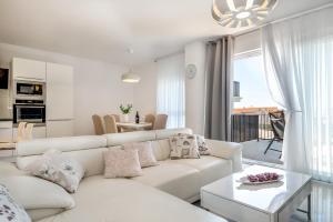 a white living room with a couch and a table at Kuća za odmor - Šibenik in Brodarica