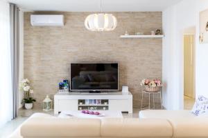 a living room with a tv and a brick wall at Kuća za odmor - Šibenik in Brodarica