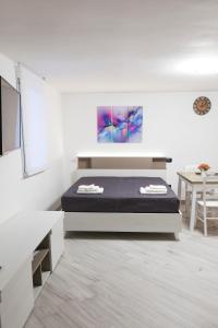 1 dormitorio con 1 cama en una habitación blanca en serendipity la terrazza house en Lecce