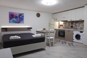 a bedroom with a bed and a table and a kitchen at serendipity la terrazza house in Lecce