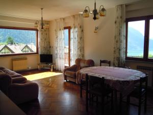 a living room with a table and some chairs at Appartamenti Rosenberger in Molveno