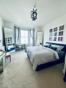 a bedroom with a large bed and a chandelier at Southsea Retreat in Southsea