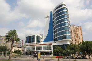 un gran edificio azul y blanco en una ciudad en Yol Is Holiday Adana, en Adana