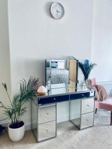 a desk with a mirror and a plant in a room at Southsea Retreat in Southsea