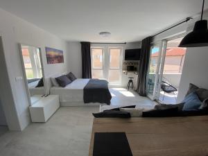 1 dormitorio con 1 cama y sala de estar en Diva Sunset Apartment, en Novalja