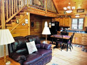 a living room with a leather couch in a cabin at Mountain Joy in Gatlinburg