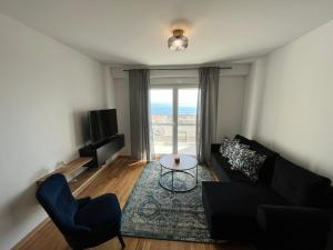 sala de estar con sofá, mesa y TV en Apartman J&M en Makarska