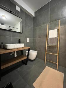y baño con lavabo, aseo y espejo. en Apartman J&M en Makarska
