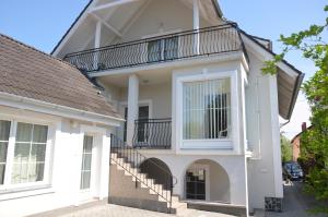 a white house with a balcony at Villa Ladver in Hévíz