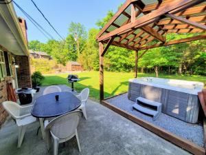 a patio with a table and chairs and a hot tub at Hoot-N-Holler in Pigeon Forge