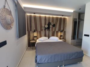 een slaapkamer met een groot bed en 2 tafels bij Casa di Angela in Mykonos-stad