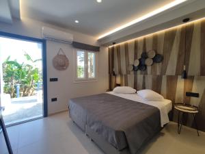 a bedroom with a large bed and a large window at Casa di Angela in Mýkonos City