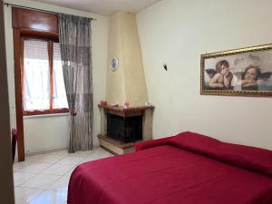 um quarto com uma cama vermelha e uma lareira em Annalisa house 134 em Nápoles