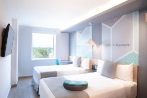 Łóżko lub łóżka w pokoju w obiekcie One Tapachula