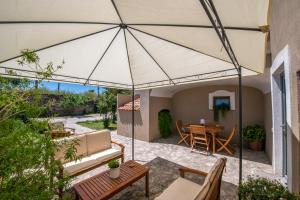 an umbrella on a patio with a table and chairs at Casa Franco in Paestum