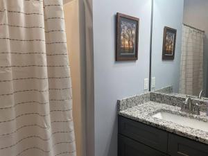 a bathroom with a sink and a mirror at Cades Cove Paradise SoftTub Spa Fireplace in Townsend +17 photos