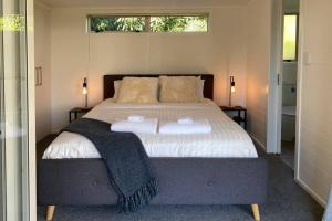 a bedroom with a bed with two towels on it at Tranquil Nest Escape with deck and garden in Auckland
