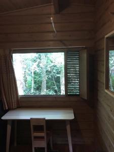 una ventana en una cabaña de madera con un banco en ella en Fins Boshuis en Meppen