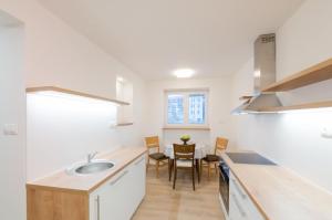 een keuken met een spoelbak en een tafel met stoelen bij Apartman RÁZUSA CENTRUM in Banská Bystrica