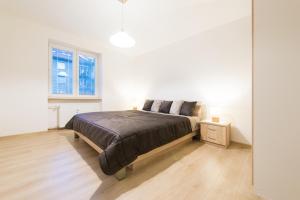 1 dormitorio con 1 cama grande en una habitación blanca en Apartman RÁZUSA centrum, en Banská Bystrica