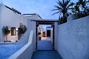 a stairway leading to a white building with a doorway at Grandma's Homes in Imerovigli