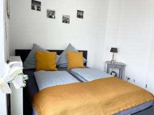 Toplage Innenstadt Köln-Neumarkt! Gemütliche Wohnung في كولونيا: سريرين في غرفة مع وسائد صفراء و زرقاء
