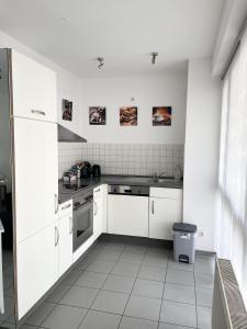 a white kitchen with white cabinets and a sink at Toplage Innenstadt Köln-Neumarkt! Gemütliche Wohnung in Cologne