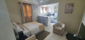 a small bedroom with a bed and a kitchen at Hastings Towers 4D - Studio Apt Opp Beach in Bridgetown