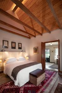 1 dormitorio con 1 cama grande y techo de madera en LAS LIEBRES RESTAURANT & HOTEL, en Colonia del Sacramento