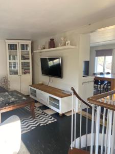 sala de estar con TV de pantalla plana en la pared en Cozy house in central Lysekil, 4-6 beds en Lysekil