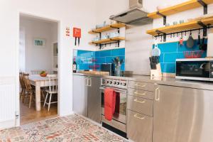 cocina con paredes azules y electrodomésticos de acero inoxidable en The Mexico Inn, Flat Two, en Penzance